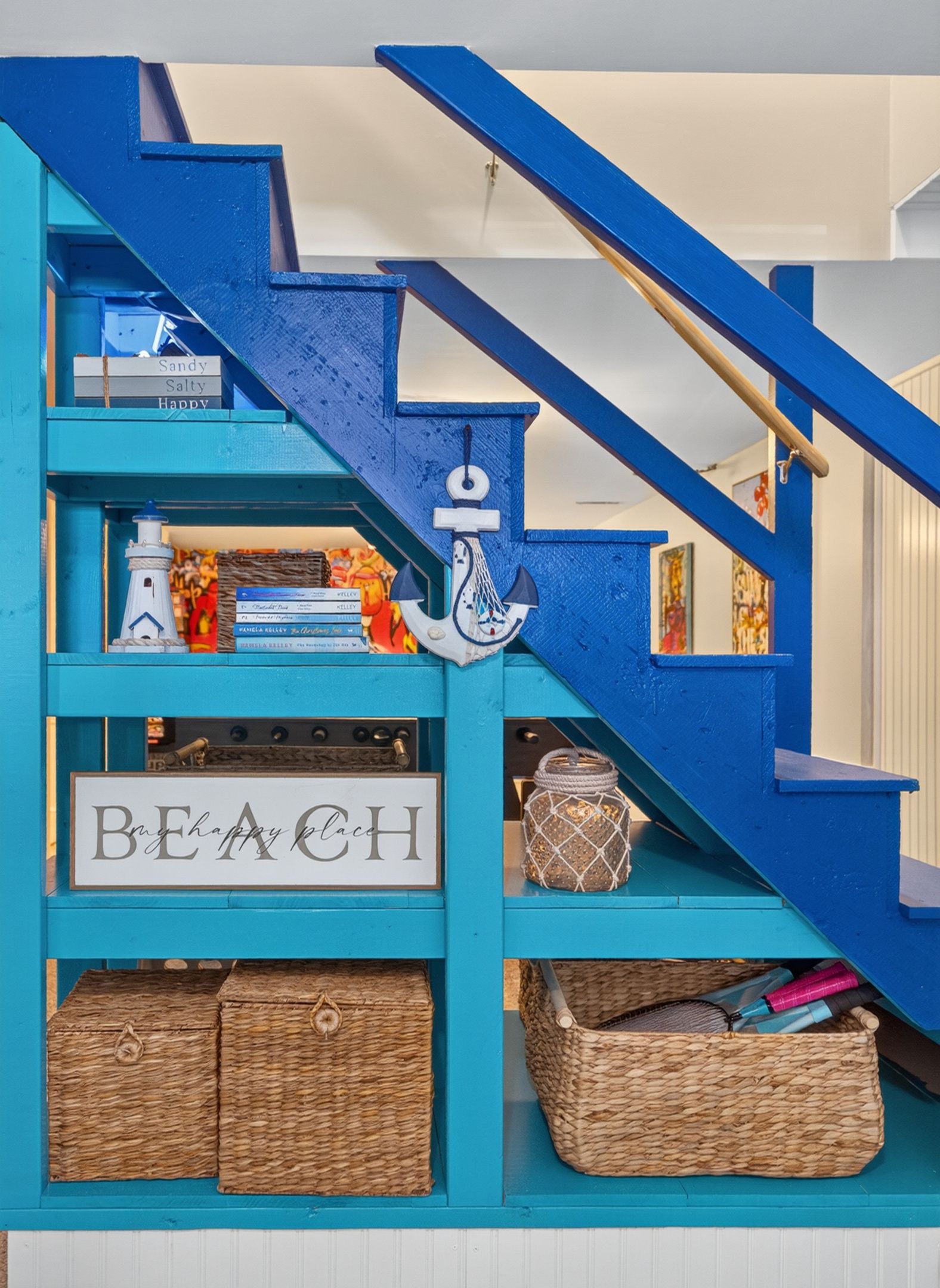 Eine blaue Treppe mit einem Schild, auf dem 'BEACH' steht, und einem dekorativen Anker.