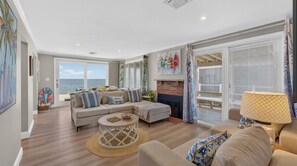 A living room with a sofa, coffee table, and a view of the ocean. - Ocean Views w/HotTub, Game Room, Movie Theater (Scituate)