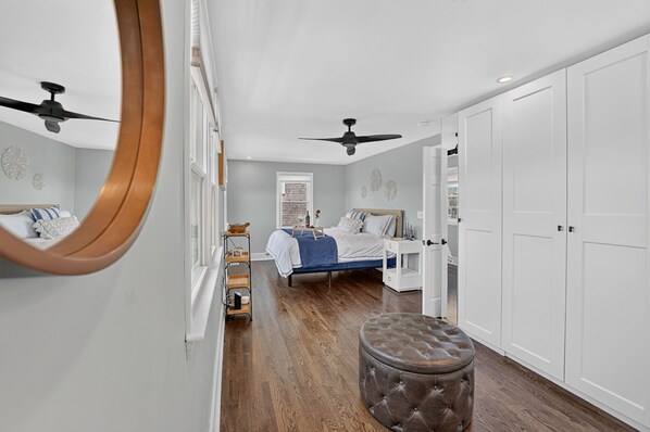 A bedroom with a bed, bedside tables, a wardrobe, and a mirror.
