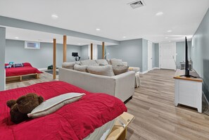 Una habitación de hotel moderna con una cama grande, un sofá, un escritorio y un televisor.