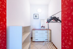 A narrow hallway with a white dresser, a mirror, and a clothing rack. - A cozy and comfortable 47 sqm apartment, perfect for four people, located on the first floor of a building with an elevator.The property is situated in a quiet yet strategic area near Parma's city center; the train station, airport, and highway entrance  (Parma)