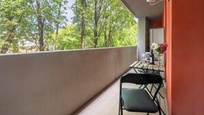 A balcony with a table and chairs, overlooking a forested area. - A cozy and comfortable 47 sqm apartment, perfect for four people, located on the first floor of a building with an elevator.The property is situated in a quiet yet strategic area near Parma's city center; the train station, airport, and highway entrance  (Parma)