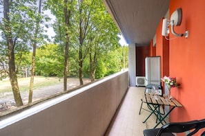 A balcony with a table and chairs, a radiator, and a view of trees. - A cozy and comfortable 47 sqm apartment, perfect for four people, located on the first floor of a building with an elevator.The property is situated in a quiet yet strategic area near Parma's city center; the train station, airport, and highway entrance  (Parma)