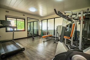 A gym with exercise equipment, a treadmill, and a mirror. - Beautiful 2-bedroom apartment in gated and secure community (Lusaka)