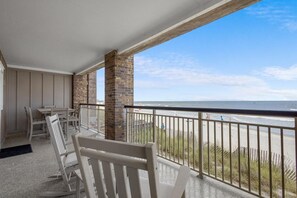 A balcony with a view of the beach, featuring a railing, a table, and a chair. - 3 Bedroom Oceanfront: Stargazing from the 2nd Flr (Pawleys Island)