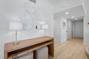 A hallway with a wooden console table, wall-mounted decorative plates, and a door leading to another room. - 3 Bedroom Oceanfront: Stargazing from the 2nd Flr (Pawleys Island)