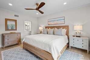 A bedroom with a large bed, a ceiling fan, a nightstand with a lamp, and a dresser. - 3 Bedroom Oceanfront: Stargazing from the 2nd Flr (Pawleys Island)