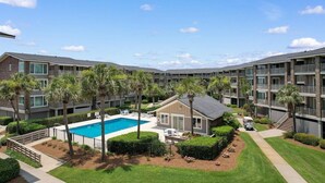 A multi-story hotel with a swimming pool surrounded by palm trees and a small building. - 3 Bedroom Oceanfront: Stargazing from the 2nd Flr (Pawleys Island)