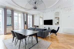 Un salon moderne avec une table à manger, un canapé et un téléviseur.