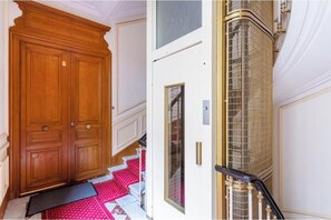 Eine hölzerne Doppeltür, eine weiße Tür mit Fenster und eine Metall-Wendeltreppe.