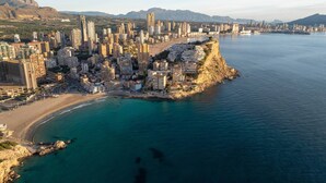 A coastal cityscape with high-rise buildings, a beach, and a mountainous backdrop. - Stylish Benidorm Apartment, Pools, Sauna & Terrace (Villajoyosa)
