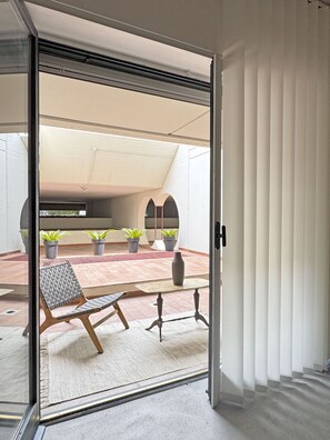 Ein modernes Interieur mit einer Schiebetür, die zu einer Außenpatiofläche führt.