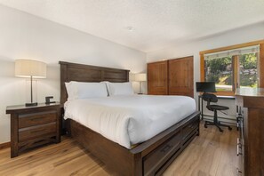 A bedroom with a wooden bed, nightstands, a desk, and a window. - Ski In/Out | A/C in Summer | Fresh Renovation 2026 (Steamboat Springs)