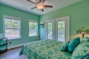 Ein Schlafzimmer mit Bett, Deckenventilator, Fenster und Tür.