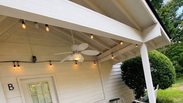 A covered porch with a bench, rocking chairs, and string lights. - Chef's Château Suite B | Queen Bed, Pool + Hot Tub (Spalding County)