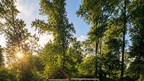 A well-maintained grassy area with a wooden playhouse and swings.