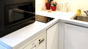 A modern kitchen with white cabinetry, a black oven, and a dishwasher. - Houlgate, near the beach, with outdoor space and parking (Houlgate)