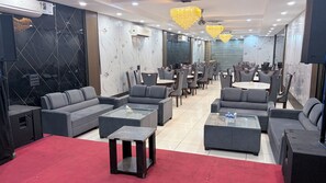 A hotel lobby with a red carpet, grey sofas, and a chandelier. - Hotel The Stay (Zirakpur)