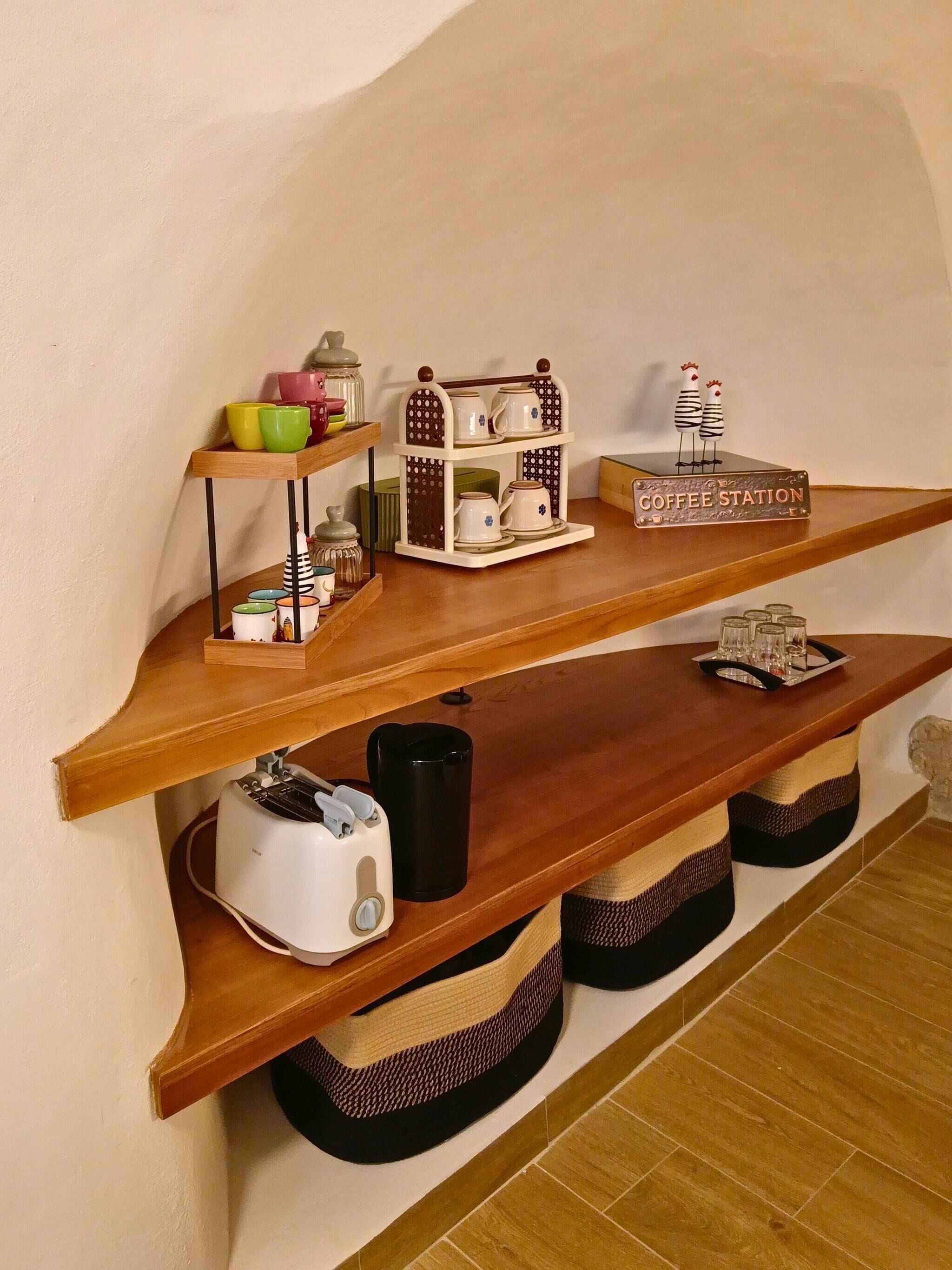 Een keuken met houten planken vol keukengerei, een koffiehoek en een broodrooster.