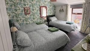 Un dormitorio con dos camas, un escritorio y una ventana con cortinas.