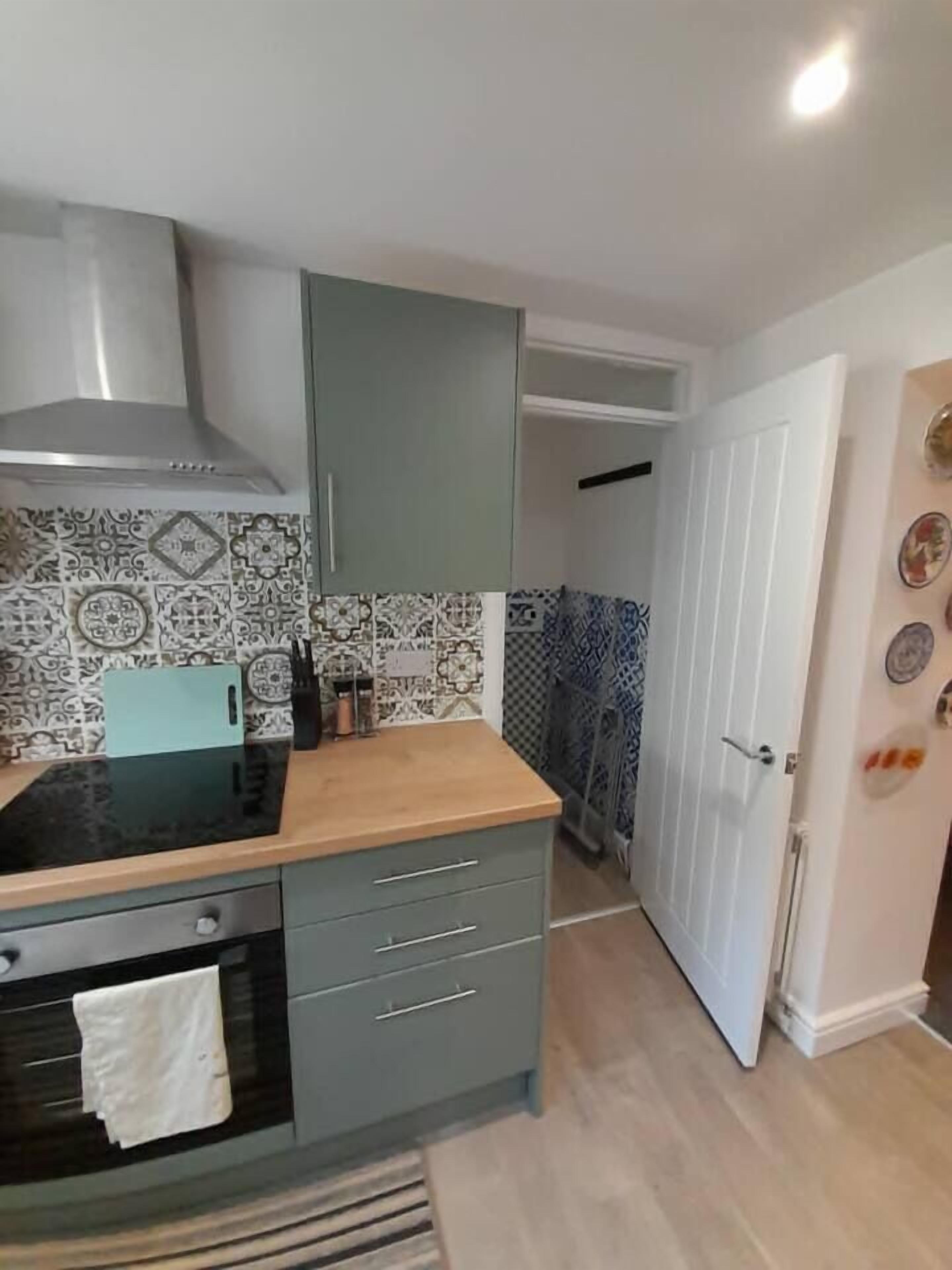 A compact kitchen with a stove, oven, and grey cabinets.
