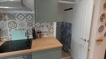 A compact kitchen with a stove, oven, and grey cabinets.