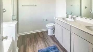 A bathroom with a shower, toilet, and sink.