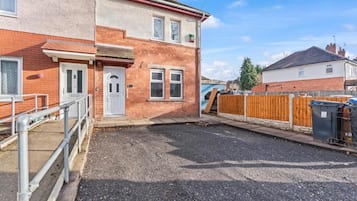 Il s’agit d’une propriété résidentielle dotée d’une allée pavée, d’une clôture en bois et d’un garage.