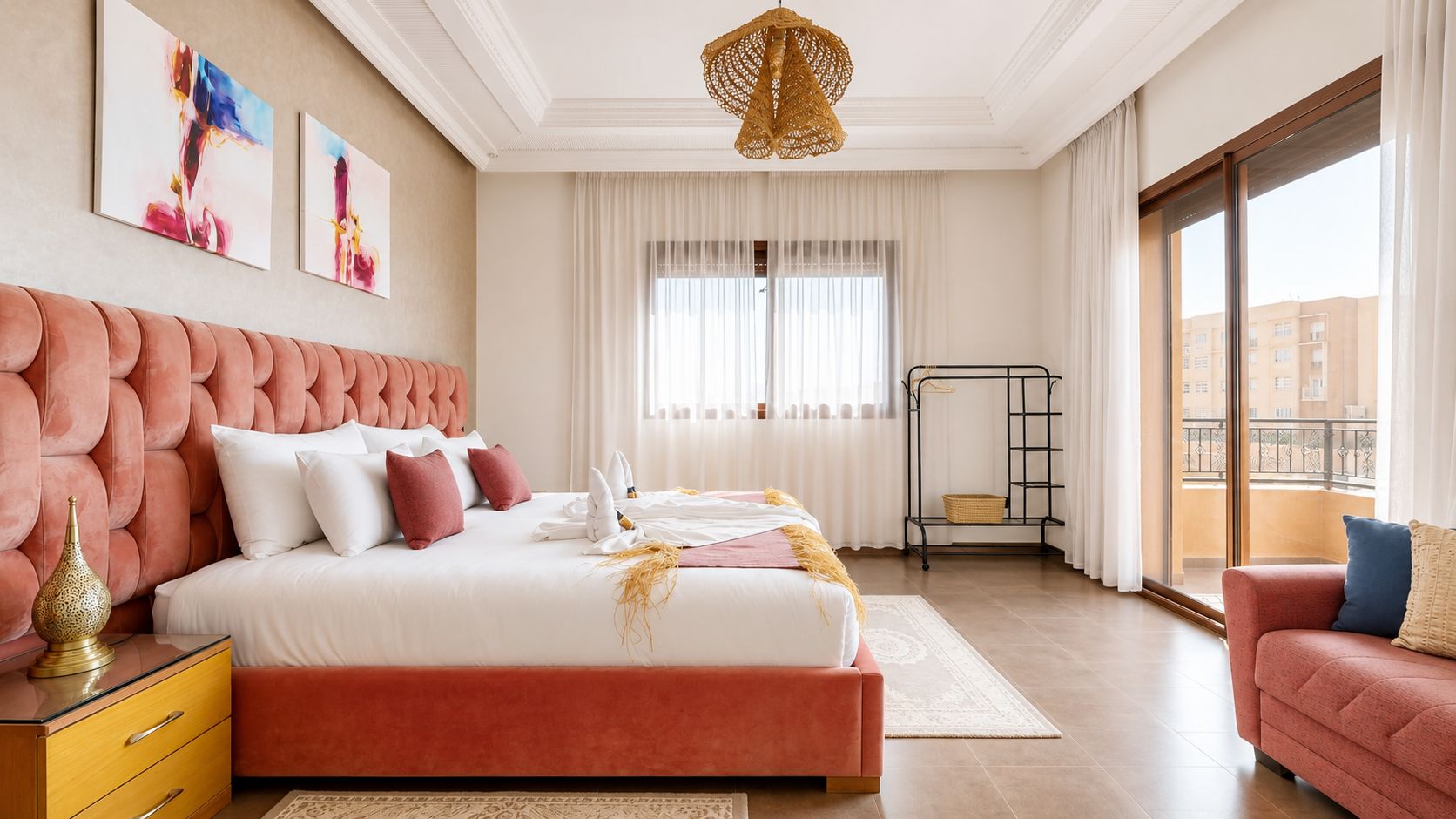 A modern bedroom with a large bed, a bedside table, a decorative lamp, and a view of the outside.
