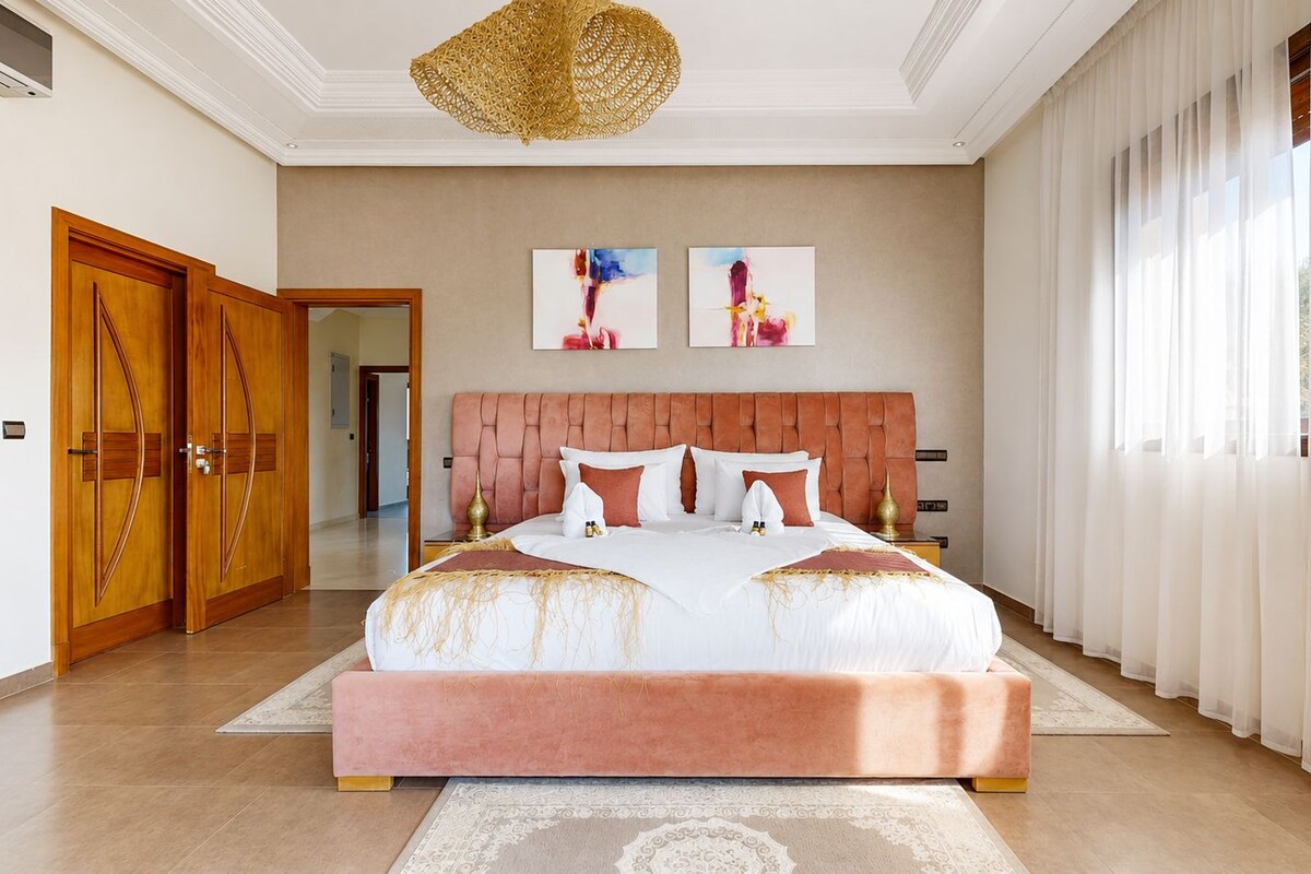 Un dormitorio amplio con una cama grande, una puerta de madera y vistas al pasillo.
