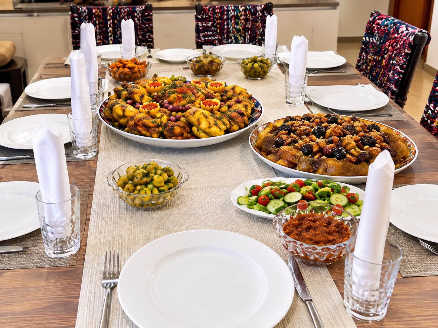A dining table set for a meal with various dishes, glasses, and cutlery.