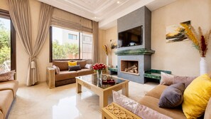 Una sala moderna con chimenea, un conjunto de sofás y una mesa de centro.