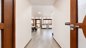 A hallway leading to a kitchen with a dining area.