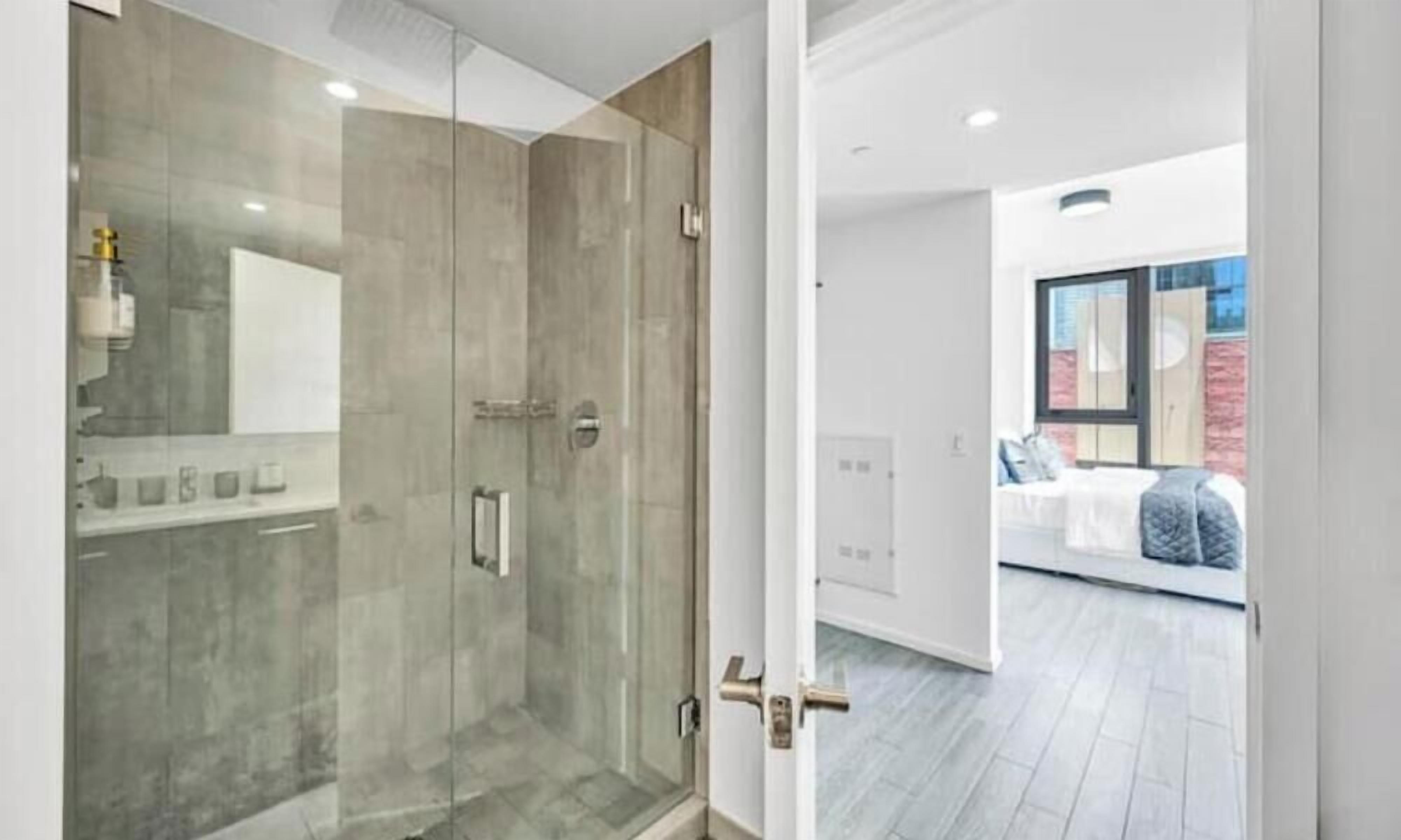 Un baño moderno con cabina de ducha de vidrio y un inodoro a la vista.