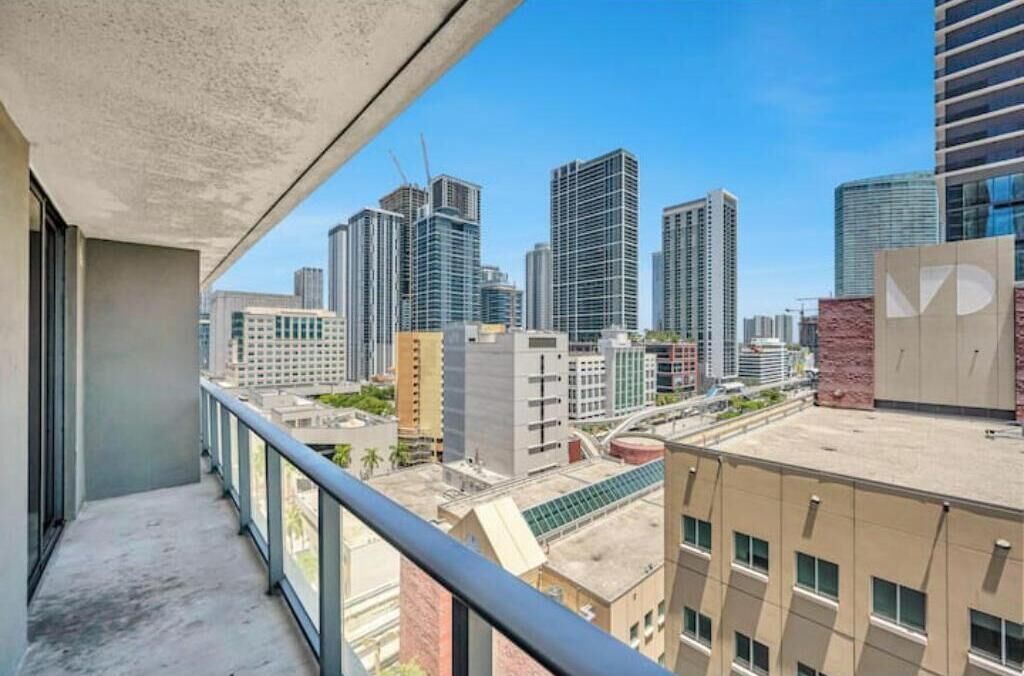 A high-rise building with a balcony overlooking a cityscape.