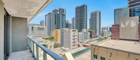 A high-rise building with a balcony overlooking a cityscape.
