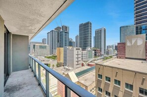 Um edifício alto com varanda e vista para a paisagem urbana.