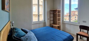 Una camera da letto con un letto, una sedia e una scaffalatura in legno.