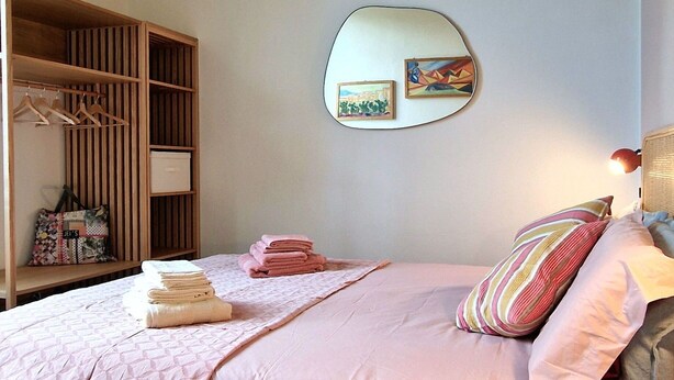 A bedroom with a bed, a wardrobe, a mirror, and a wall-mounted light fixture. - City / Village Apartment in Viareggio with 2 bedrooms sleeps 5 (Viareggio)