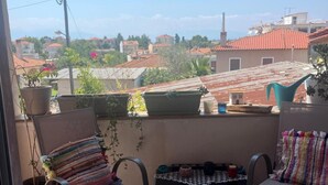 A balcony with two chairs, a small table, and potted plants. - Apartment 'Elea' with Mountain View, Wi-Fi and Air Conditioning (Epanomi)