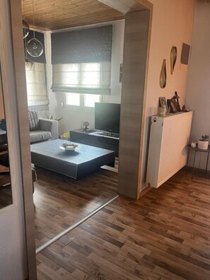 A modern living room with a sofa, coffee table, and television. - Apartment 'Elea' with Mountain View, Wi-Fi and Air Conditioning (Epanomi)