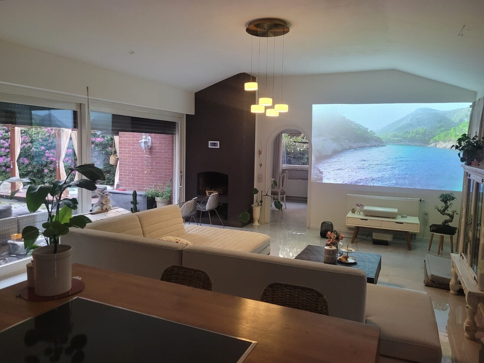 Una sala de estar moderna con sofá, mesa de comedor y vista a una masa de agua.