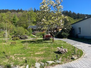 A residential area with a paved driveway, a picnic table, and a building with a sloped roof. - Apartment 'Suiten Im Alten Berghotel Jakob' with Mountain View, Private Terrace and Wi-Fi (Eslohe)