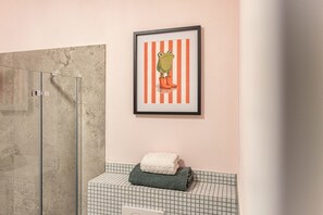 A bathroom with a glass shower enclosure, a framed picture on the wall, and a towel rack with folded towels. - Apartment 'Suiten Im Alten Berghotel Jakob' with Mountain View, Private Terrace and Wi-Fi (Eslohe)