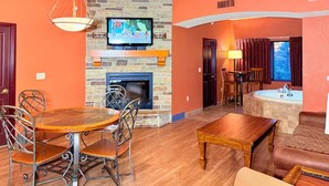 A living room with a fireplace, television, dining table, and seating area. - Spacious 3BR/3BA with Jacuzzi, Fireplaces & FREE Waterpark Passes! (Wisconsin Dells)
