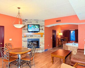 A living room with a fireplace, television, dining table, and seating area. - Spacious 3BR/3BA with Jacuzzi, Fireplaces & FREE Waterpark Passes! (Wisconsin Dells)