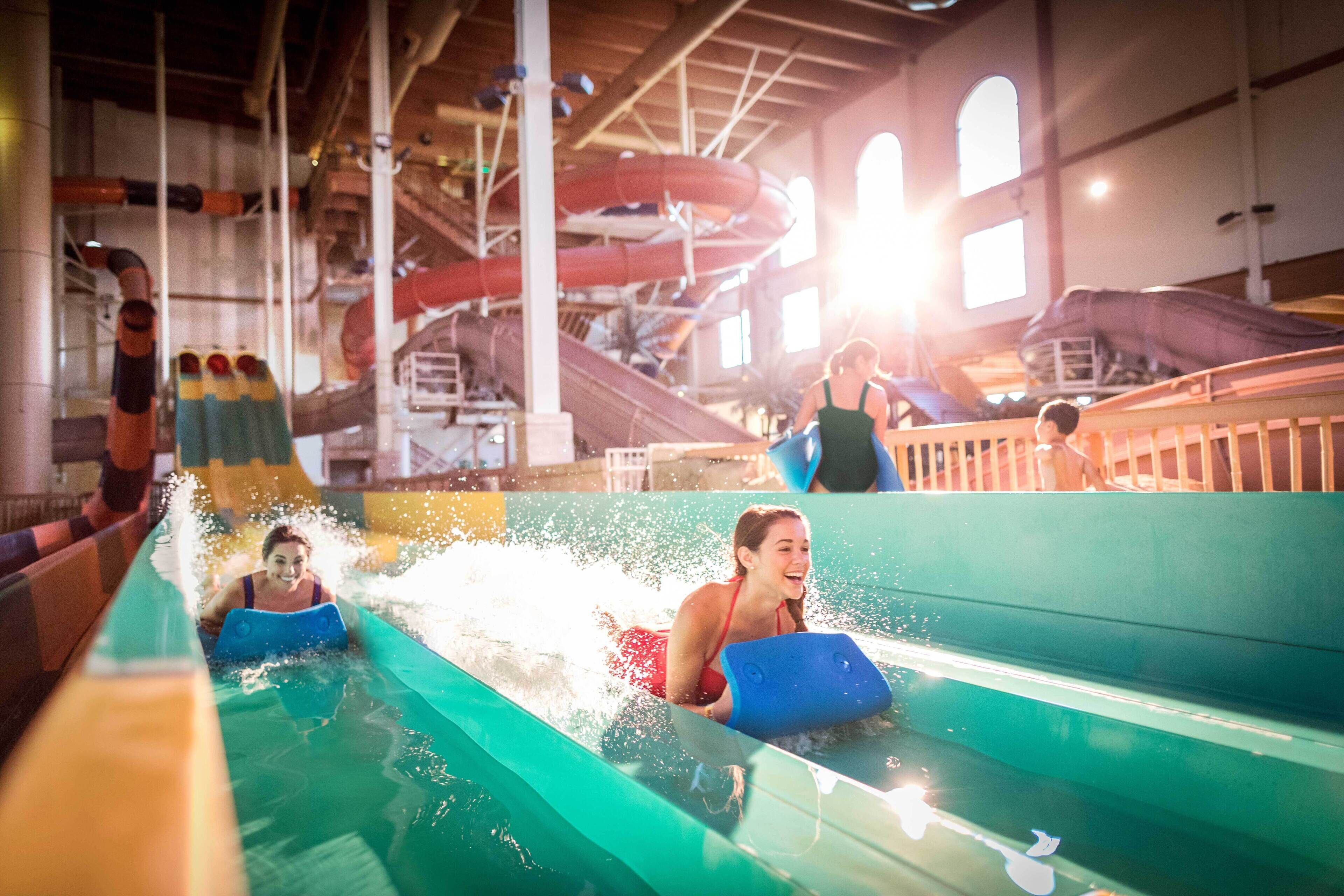 Un parc aquatique intérieur avec des toboggans et un espace piscine.