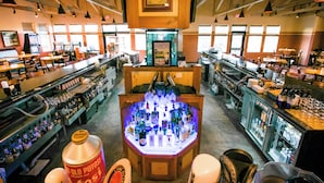 A bar area with a central display of bottles, shelves with bottles, and a wooden ceiling. - Spacious 3BR/3BA with Jacuzzi, Fireplaces & FREE Waterpark Passes! (Wisconsin Dells)