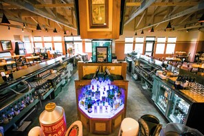 A bar area with a central display of bottles, shelves with bottles, and a wooden ceiling. - Spacious 3BR/3BA with Jacuzzi, Fireplaces & FREE Waterpark Passes! (Wisconsin Dells)