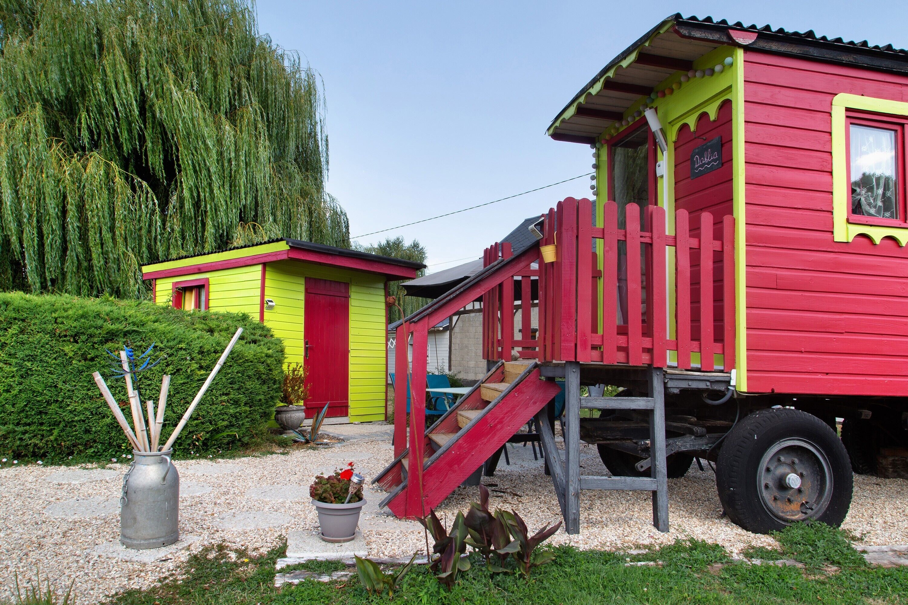 Un bâtiment aux couleurs rouge et jaune, avec un escalier rouge et un petit porche.
